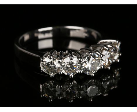 An 18ct white gold and diamond five stone ring, claw set with a row of circular cut diamonds graduating in size to the centre