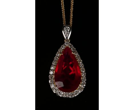 An 18ct gold, ruby and diamond drop shaped pendant, claw set with a drop shaped ruby within a surround of circular cut diamon