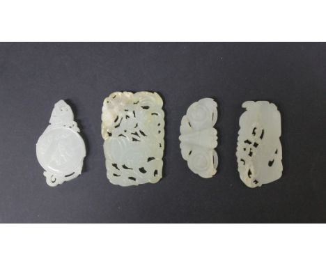 A group of four Chinese jade pendants, Qing dynasty and later, including one of pale celadon tone carved and pierced in the f