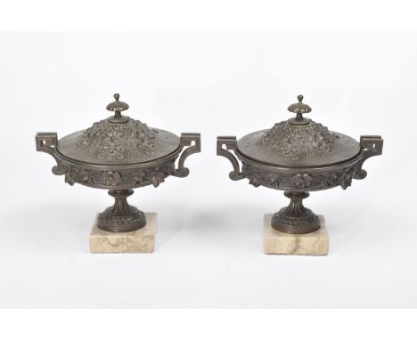 A pair of 19th century bronzed lidded urnsPossibly from a clock garniture each cast in relief with trailing vinery and flower