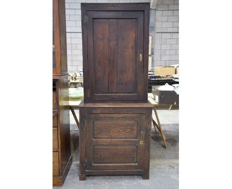 A 17th/18th century oak hall cupboard, Having a single fielded panelled door enclosing three shelves, the lower section with 