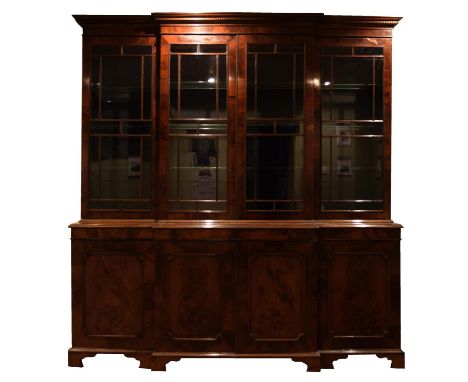 An impressive Georgian mahogany break front bookcase Having a moulded dentil cornice above four astragal glazed doors enclosi