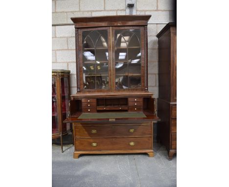 An early 19th Century mahogany secretaire bookcaseThe moulded cornice above two astragal glazed doors flanked by spirally flu