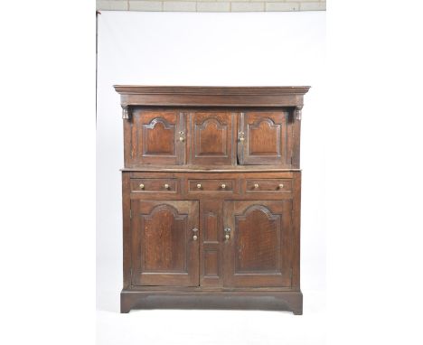 A 17th Century oak court cupboardHaving a moulded cornice above a plain frieze and a central fielded panel flanked by two pan