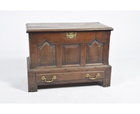 An 18th Century oak coffer bachHaving a rectangular moulded top above three panels and a single drawer applied with brass swa