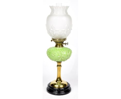 A Victorian brass oil lampHaving an etched glass shade moulded in relief with fleur-de-lys above an opaque green glass reserv