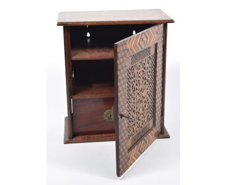 A late 19th early 20th Century parquetry and fretwork specimen chestThe single door with a central fretwork panel enclosed by