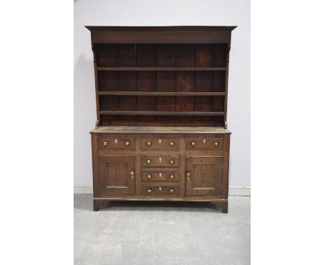 A late 18th century oak welsh dresser,the high back with a moulded cornice above a plain freeze and three shelves, the base w