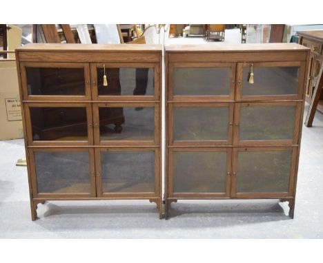 A pair of early 20th Century oak Minty type bookcasesEach bookcase with three pairs of graduated glazed doors, raised upon br