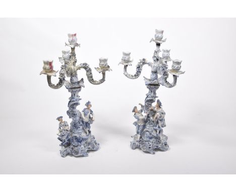 A near pair of blue and white Dutch style ceramic candelabraThe highly decorated body raised on scroll feet, the body decorat