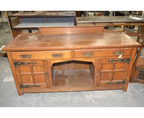 An early 20th oak arts and crafts mirror back sideboard, the architectural back with two stained glass cupboard doors above a