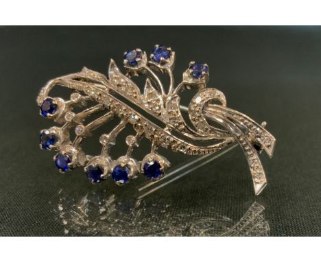 An 18ct white gold diamond and sapphire leaf shaped floral spray brooch, unmarked, 6.6g, 4.5cm, Mappin &amp; Webb Ltd box 