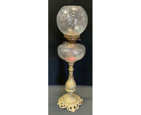 A Victorian oil lamp, clear glass reservoir, brass floral column, globular shade, 69cm high. 