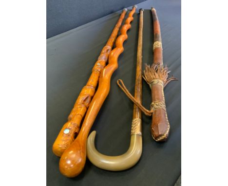 A stained horn walking stick, gold plated ferule;  others carved Maori style;  North African, etc (4) 