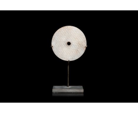 Full title: A Chinese white jade bi disc, HanDescription:Dia.: 6 cm (the jade)H.: 11,5 cm (incl. stand)The absence of a condi