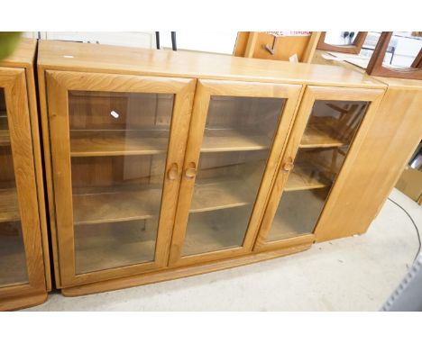 Ercol Pale Elm Bookcase / Display Cabinet with three bevelled glazed doors enclosing adjustable shelves, 136cm long x 98cm hi