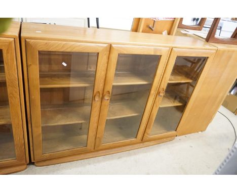 Ercol Pale Elm Bookcase / Display Cabinet with three bevelled glazed doors enclosing adjustable shelves, 136cm long x 98cm hi