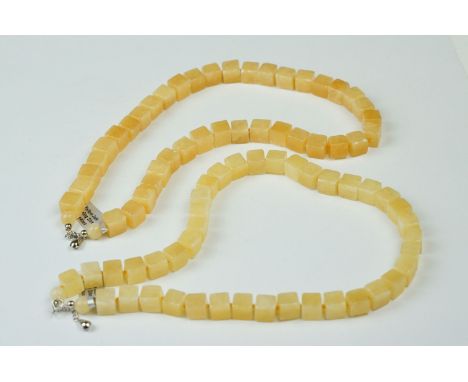 A Yellow Jade necklace with sterling silver clasp together with another similar. 