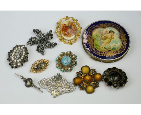 A collection of vintage brooches to include a silver example together with a powder compact. 