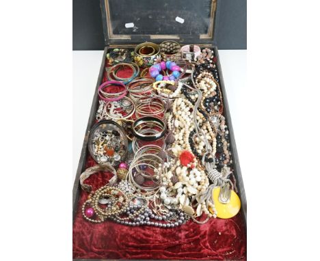 A collection of mainly vintage and contemporary costume jewellery contained within a glass topped table top display case. 