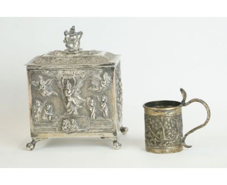 An antique white metal tea caddy with hinged lid and angelic repousse decoration together with a miniature cup. 