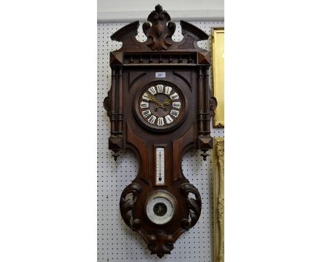 A carved French oak clock/weather station, armorial pediment, Roman numerals on enamelled shield shaped escutcheons, flanked 