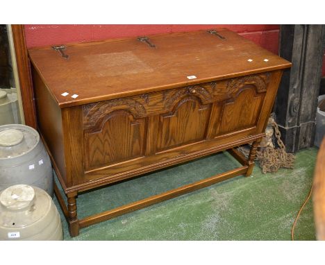 An oak Jaycee entertainment centre unit, hinged top, three fielded panel fall front, turned supports. 74cm high x 115cm wide 