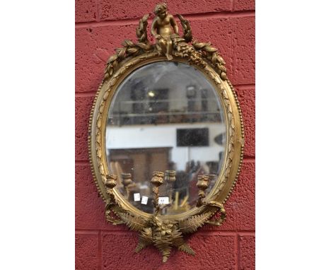 A 20th century three light oval gilt cherub mirror