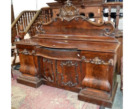 An early 19th century flame mahogany sideboard, galleried back, pierced leafy pediment, inverted bowed breakcentre, long draw