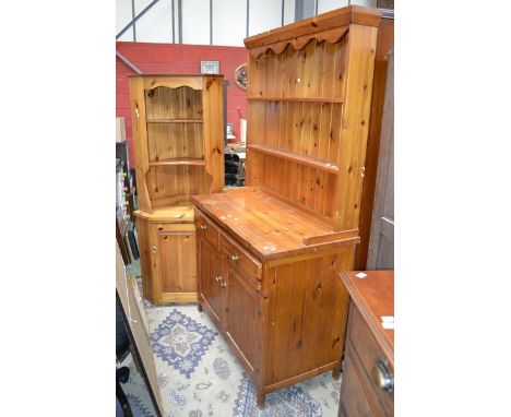 A pine dresser, two shelves to top, two short drawers over two door cupboard to base; a pine floor standing corner cupboard, 