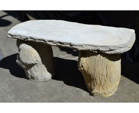 Garden ornaments - a reconstituted stone bench, obround seat supported by tree trunk effect columns.