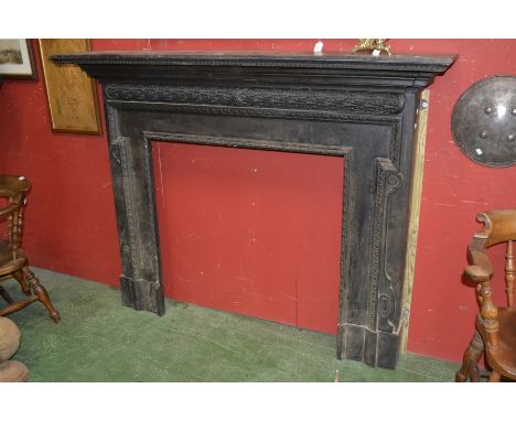 An early 20th century large cast iron fire surround,stepped mantel shelf with dentil frieze, the surround cast in geometric p