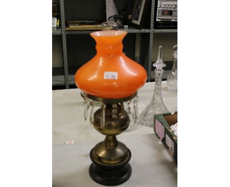 Late Victorian brass oil lamp: on wooden plinth base, with chimney and orange shade. 