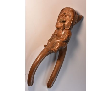 A Black Forest novelty lever-action nut cracker, carved as a gnome, full-length, 27.5cm long, early 20th century