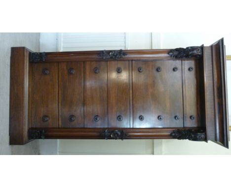 An early Victorian rosewood Wellington chest, the hinged top having a step moulded edge, enclosing a shallow compartment, ove