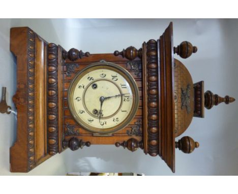 A late 19th/20thC Continental walnut cased mantel clock with carved brick effect, egg-and-dart and turned ornament, having a 