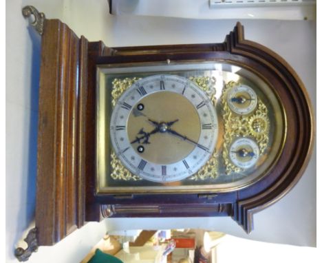 An early 20thC mahogany cased bracket clock, having an arched top and glazed, lacquered brass framed window, between inlaid s