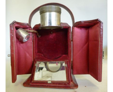 An Edwardian nickle plated and simulated maroon hide covered, traveller's projection timepiece case, having twin, hinged flap