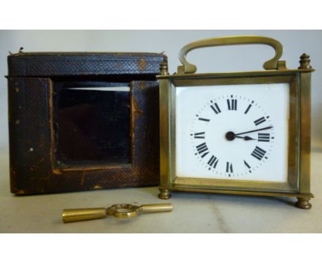 An early 20thC lacquered brass cased carriage timepiece of rectangular box design, having a single bevelled window glass and 