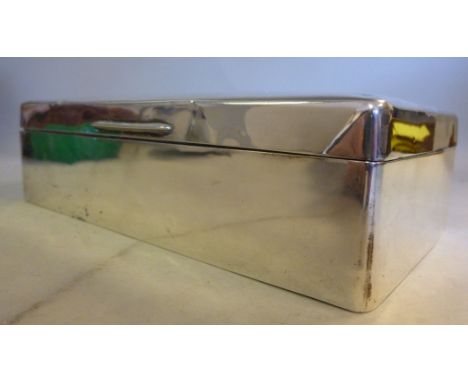 A silver cigarette box, having straight sides and engine turned decoration on the hinged lid, enclosing a cedar lined interio
