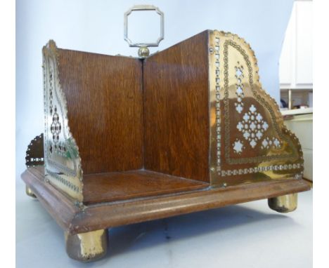 A late Victorian light oak and brass mounted, rotating, tabletop bookstand with a central handle, the four compartments havin