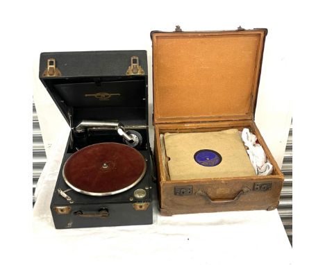 Vintage record player together with a selection of records within a storage case 