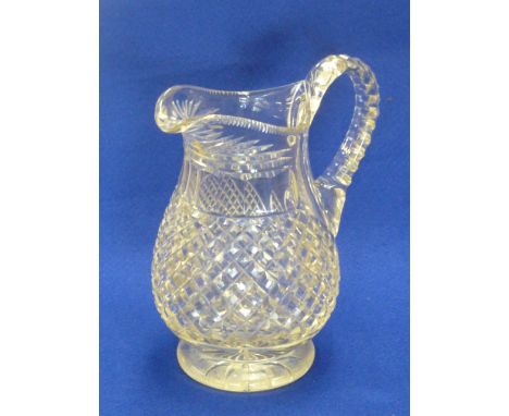 A 19th Century cut glass Jug, the yellow tinge glass cut with hob nails and on circular foot with star cut base, 21cm high  C