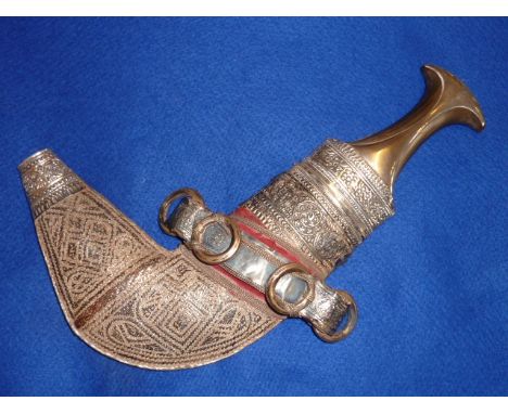 A traditional Omani style white metal Dagger (Khanjar) with sheath, the waisted horn handle above a horizontal band of styliz