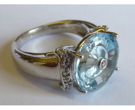 A ladies 9 carat white gold Ring centrally set with a large hand cut light blue stone (possibly an aquamarine), with diamond 