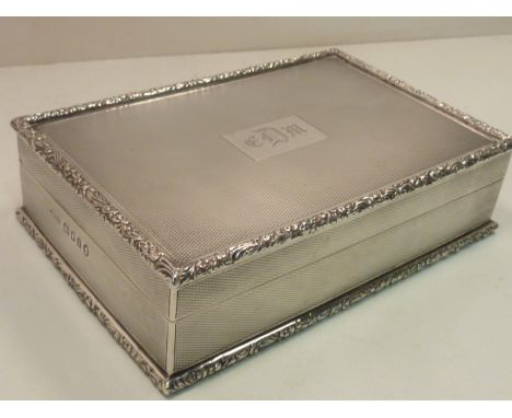 A heavy thick gauge hallmarked silver Cigarette Box, foliate cast edges, engine turned decoration and with central rectangula