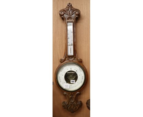 An Edwardian carved oak barometer and thermometer W.25cm