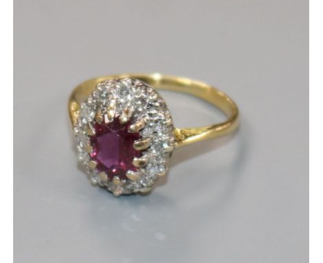 An 18ct gold, ruby and diamond oval cluster ring, size L.