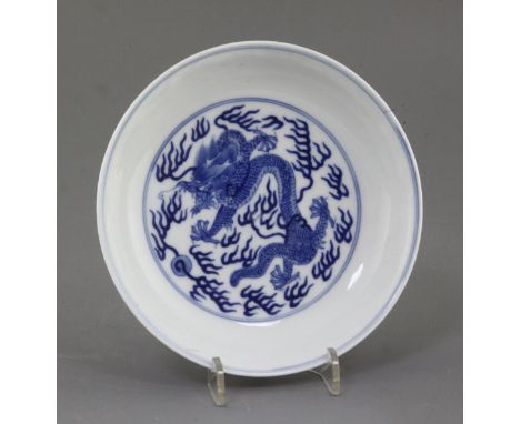 A Chinese blue and white 'dragon' dish, the interior with a single dragon chasing a flaming pearl, the exterior with two drag