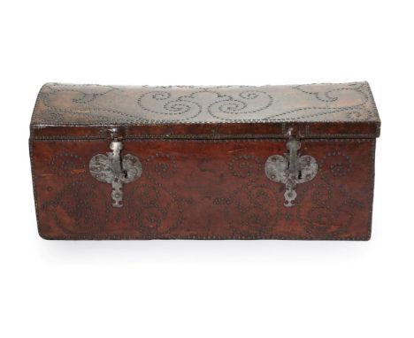 A George III Trunk, mid 18th century, covered in dark brown leather with decorative brass studding, the domed lid enclosing a